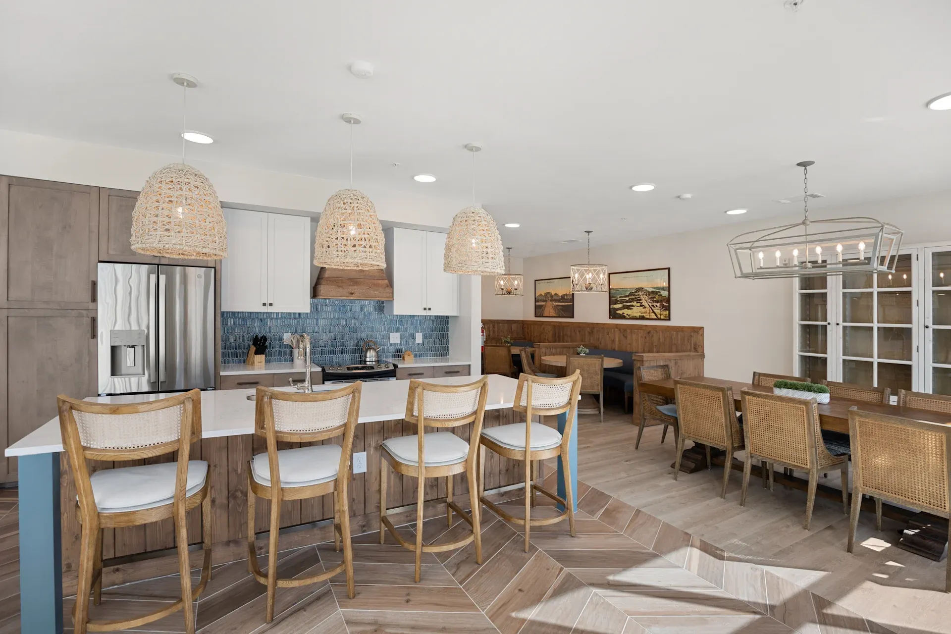 Spacious kitchen and dining area with wood accents, blue tile backsplash, and woven pendant lights.